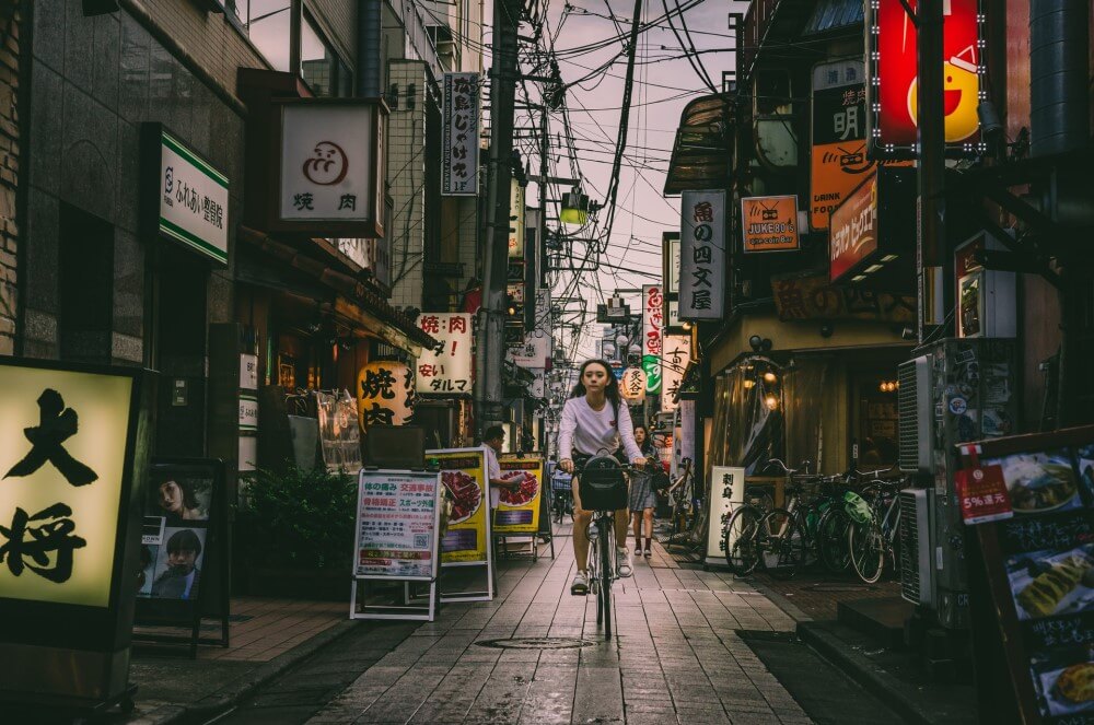 a woman on a bicycle in a Japanese street