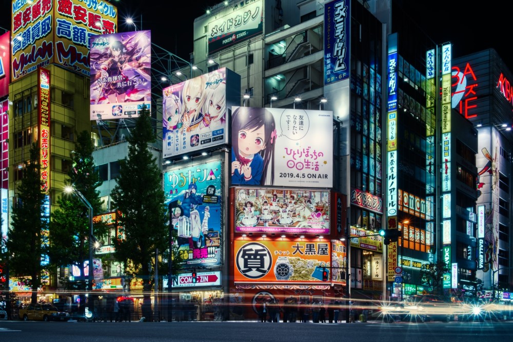 a brightly lit modern street in Tokyo showing