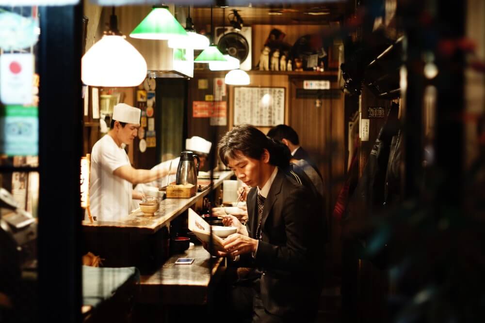 A man in a Japanese restaurant reading