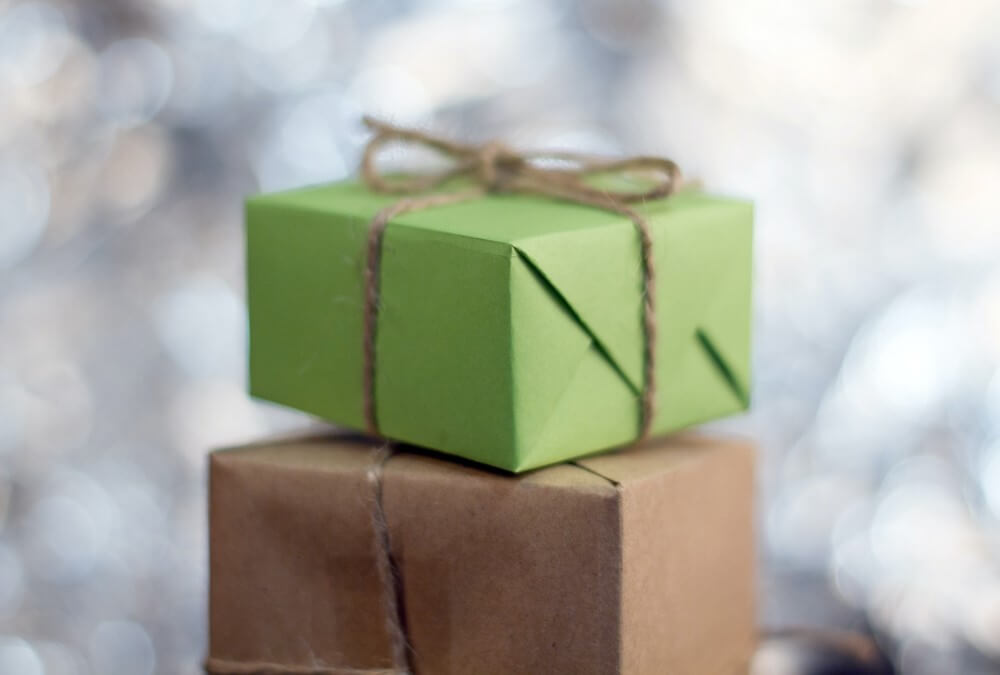пара подарков, завернутая в коричневую и зеленую бумагу