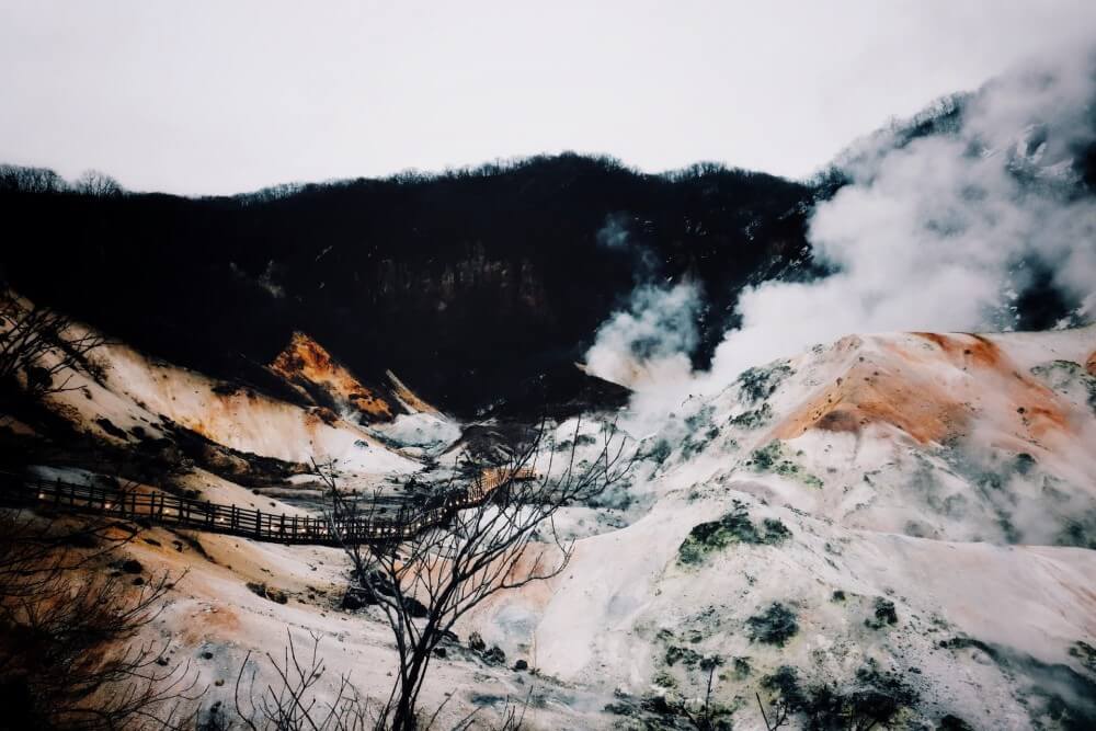 steam rising from snowy volcano banks in Japan