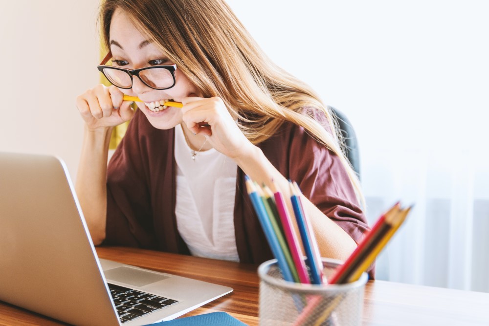 woman-biting-pencil-while-working