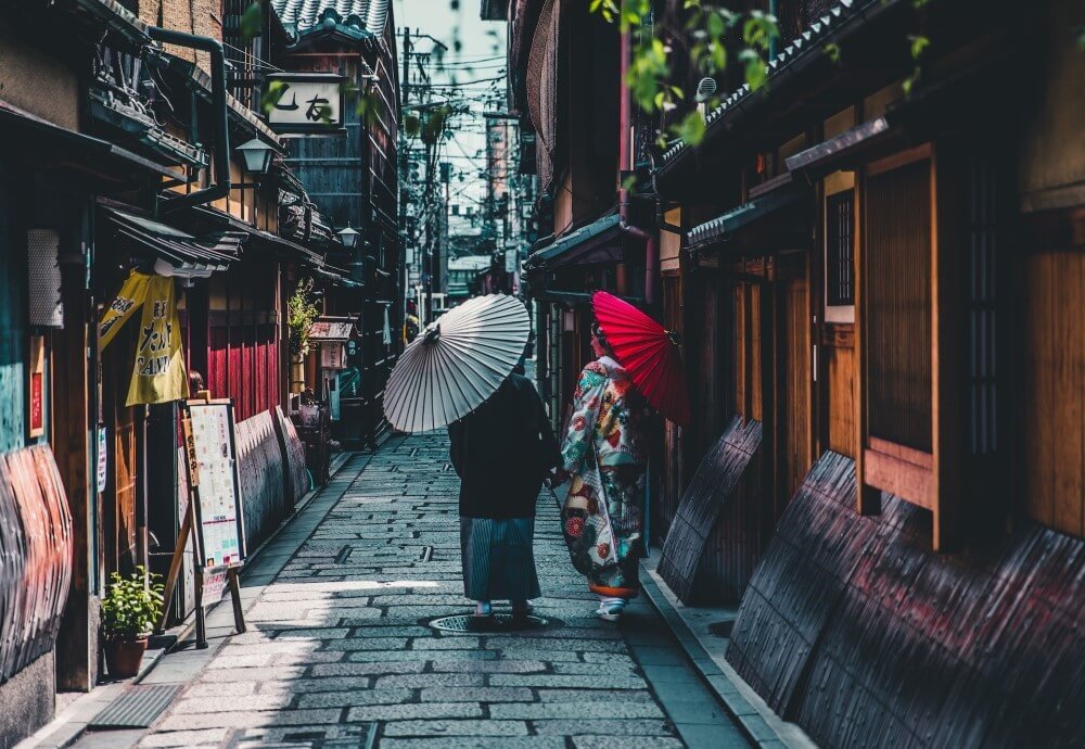 two women with parasols on a Japanese street
