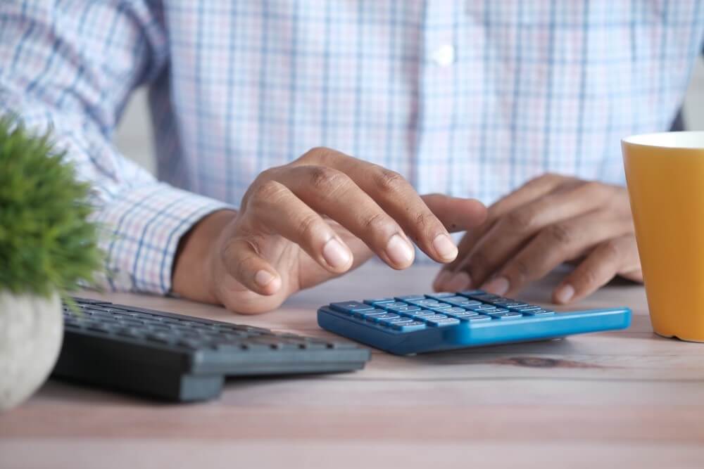 a person typing on a calculator