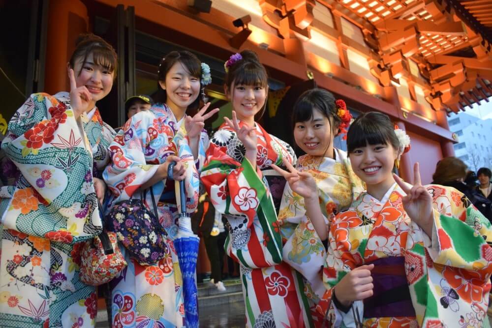 a group of smiling Japanese girls in kimonos