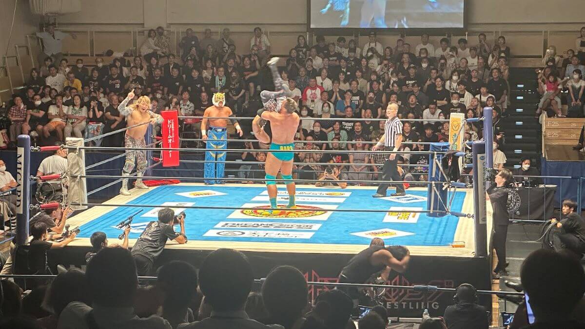 two men fighting in a pro wrestling arena in Japan