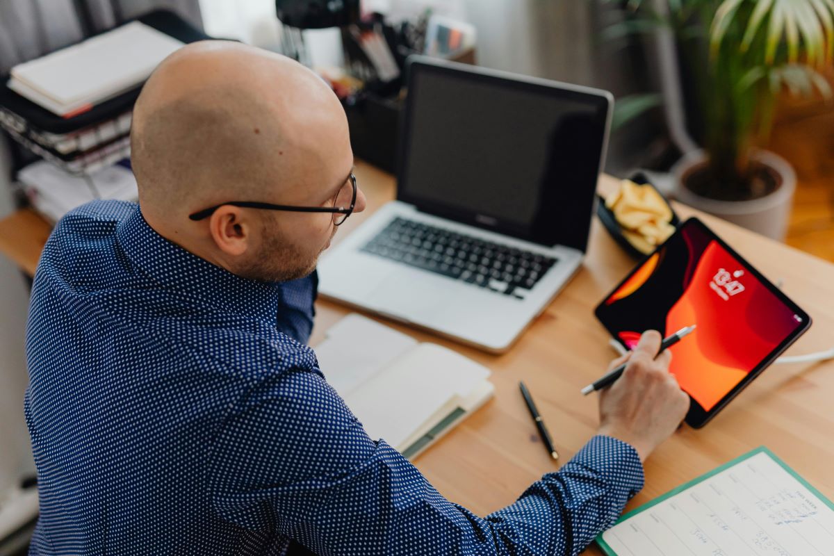 a bald man working on his laptop