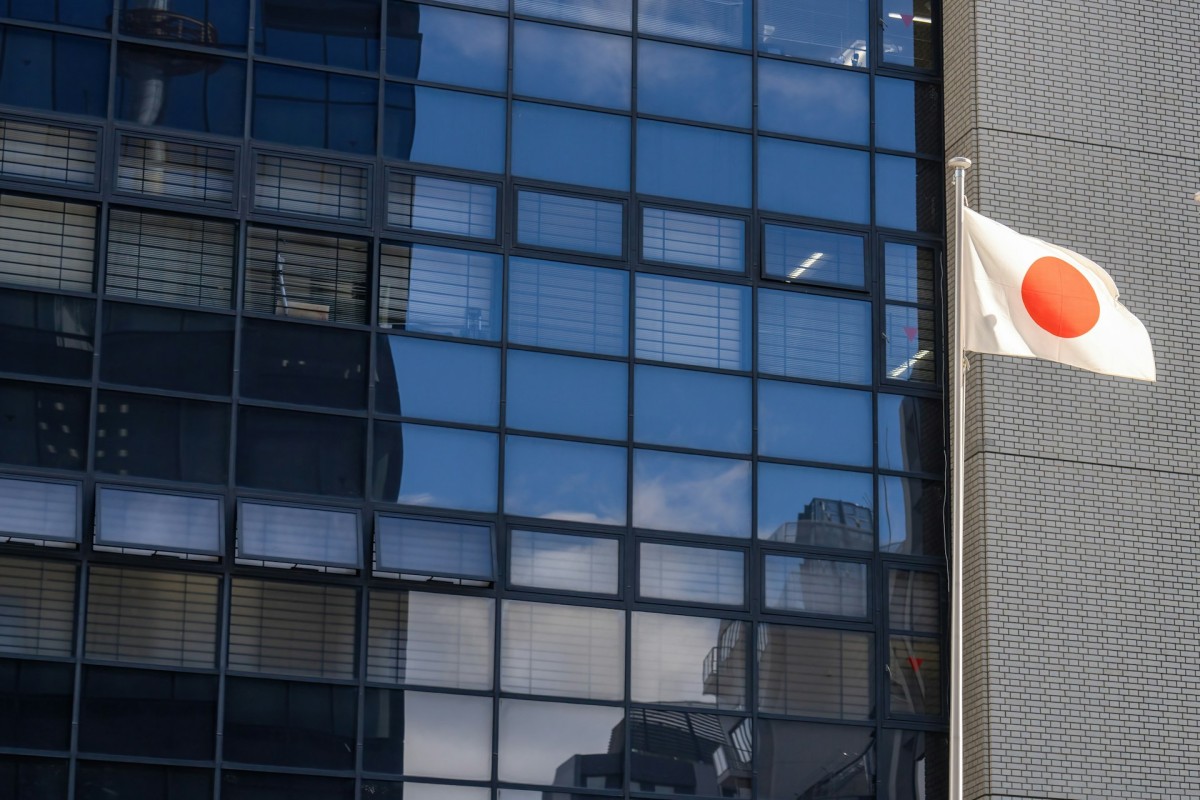 A Japanese flag in front of a modern building